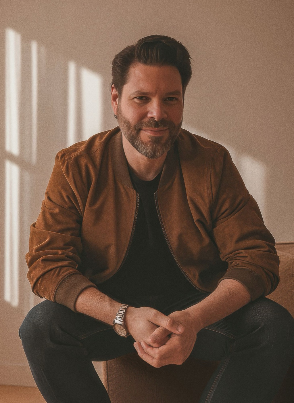 Jonathan Greye sitting in a sunlit studio