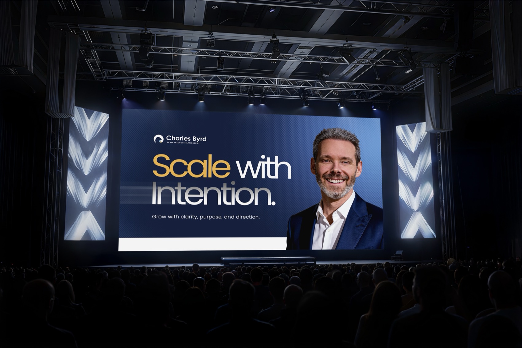 Conference stage screen reading Scale with Intention beside a photo of Charles Byrd