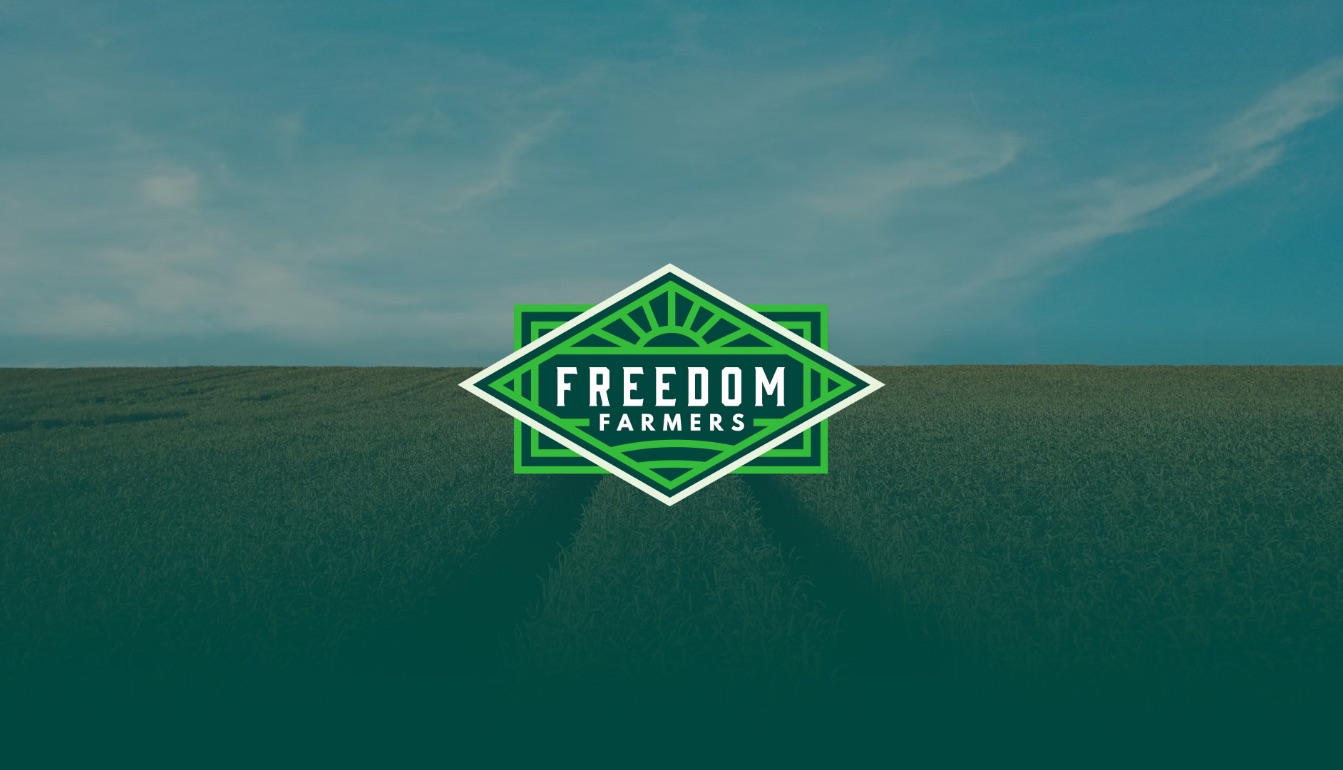 Freedom Farmers diamond badge logo over a green field