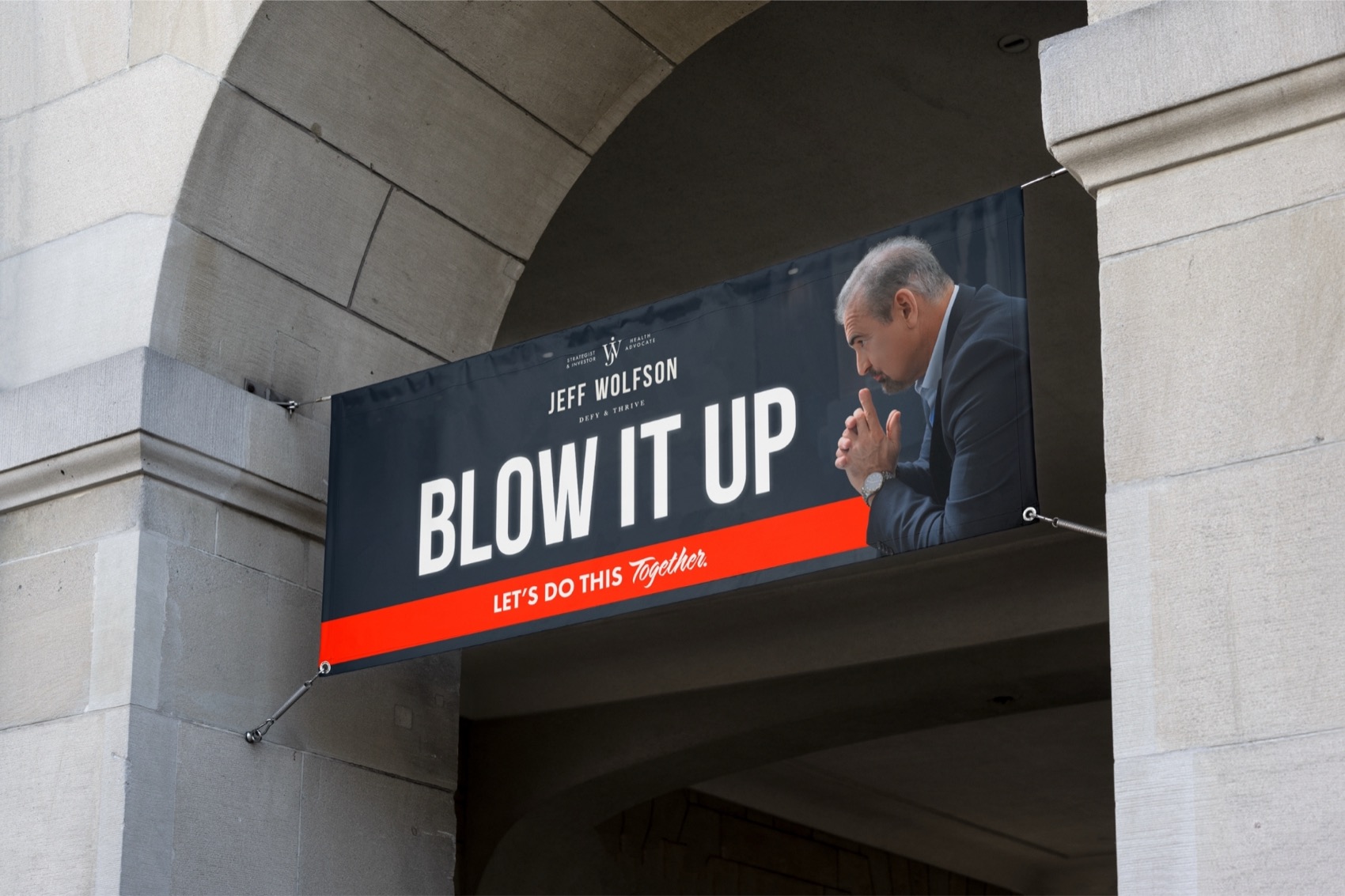 Blow It Up banner hanging in a stone archway