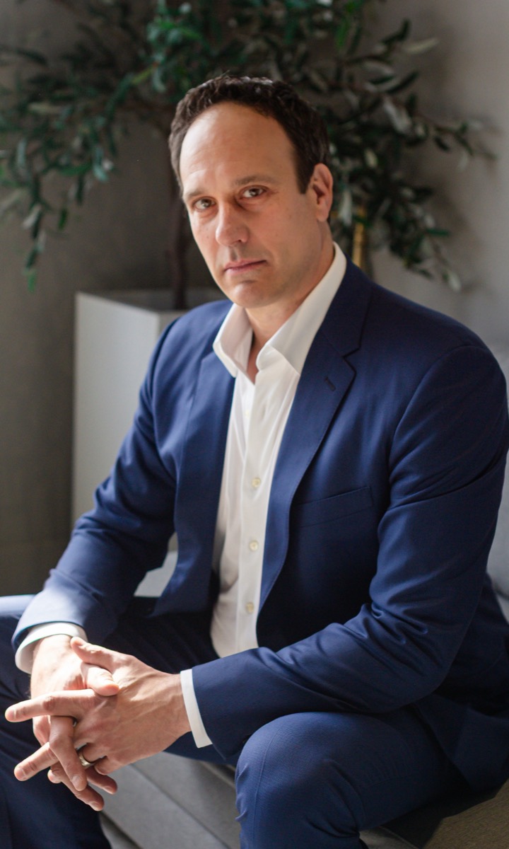 Michael Bernoff seated in a blue suit, looking at the camera