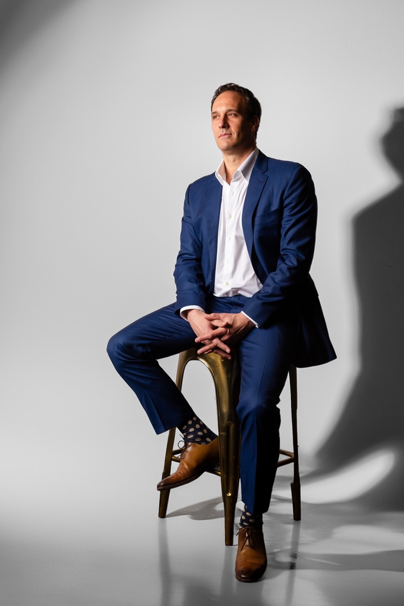 Michael Bernoff seated on a stool against a light backdrop