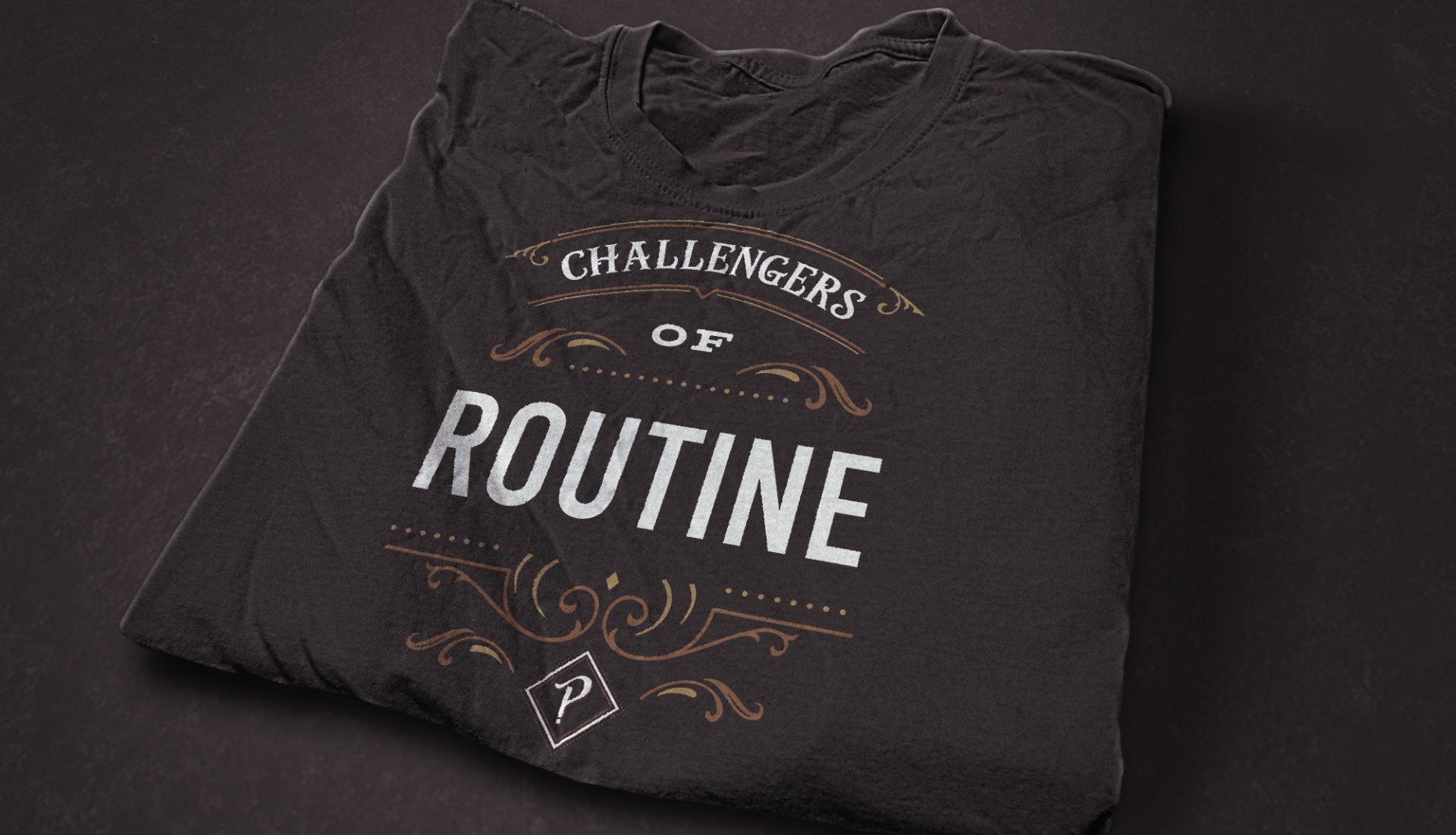 Folded black Pith & Pally shirt printed with Challengers of Routine