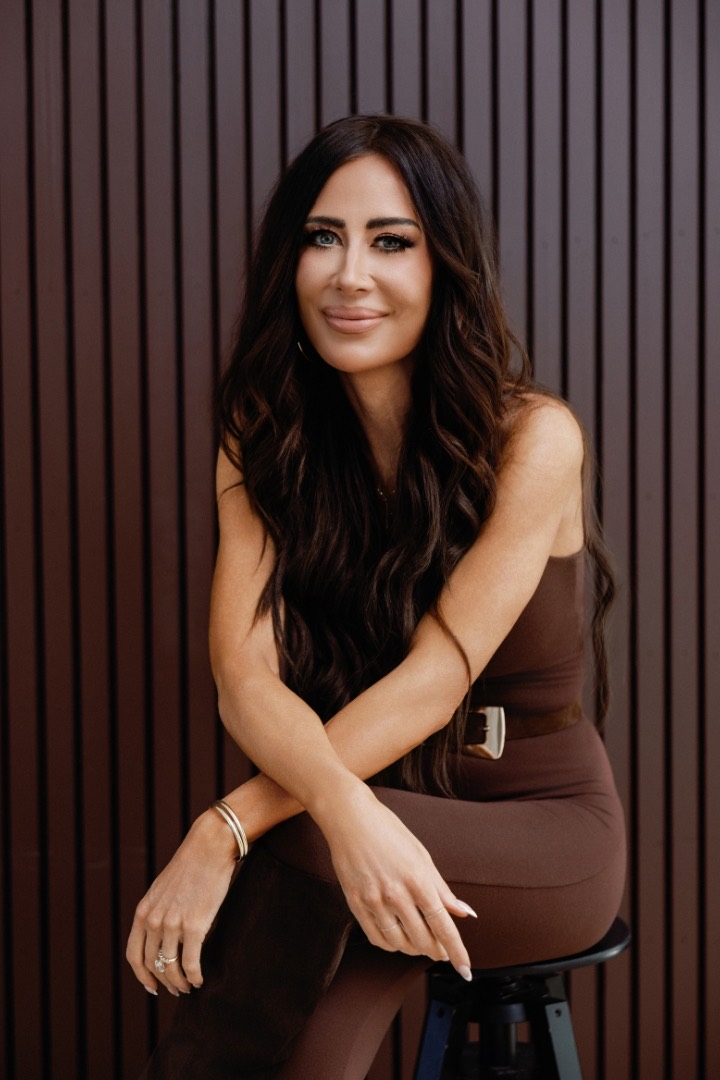 Amber Capone seated against a wood-slat wall