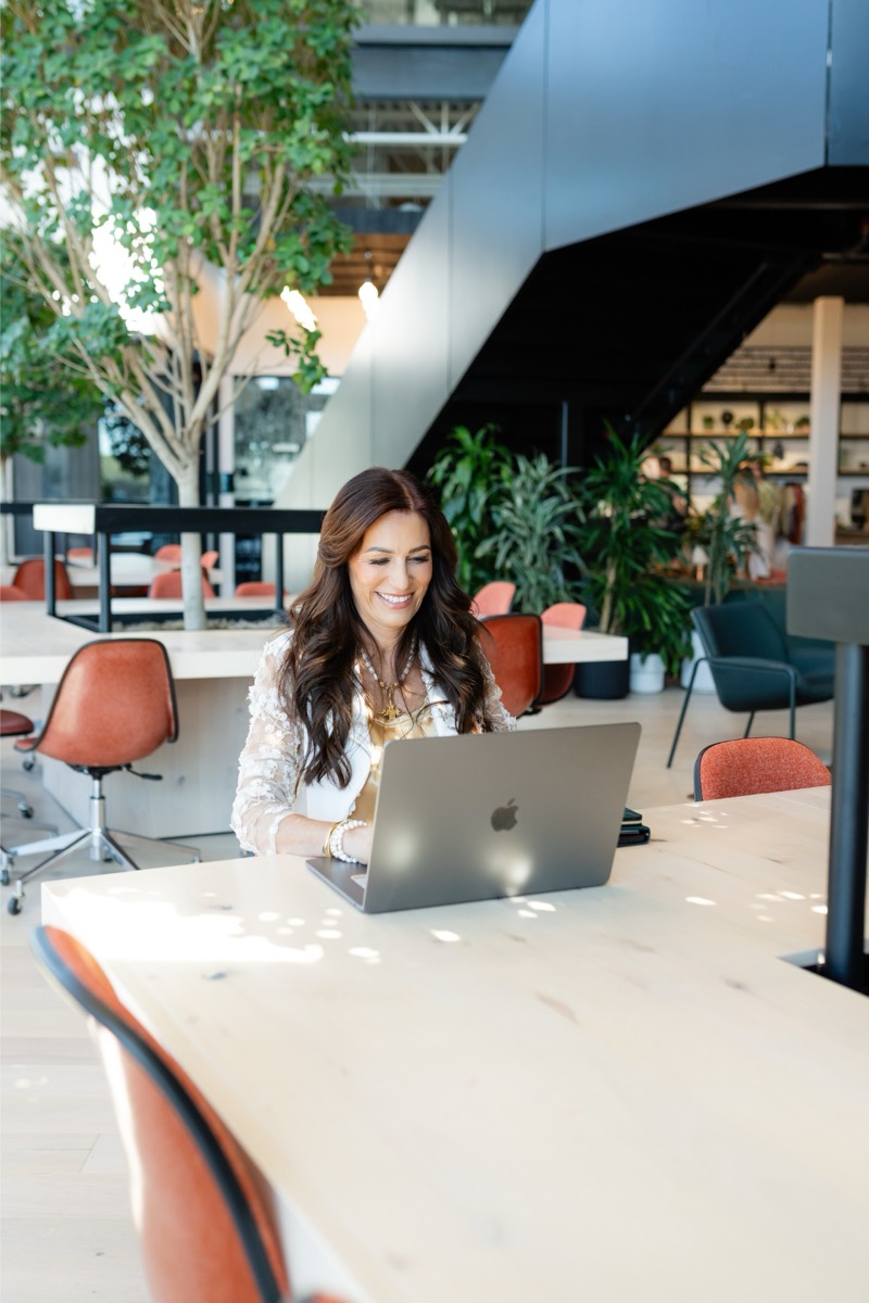 Tina Schaaf working on a laptop in an open office